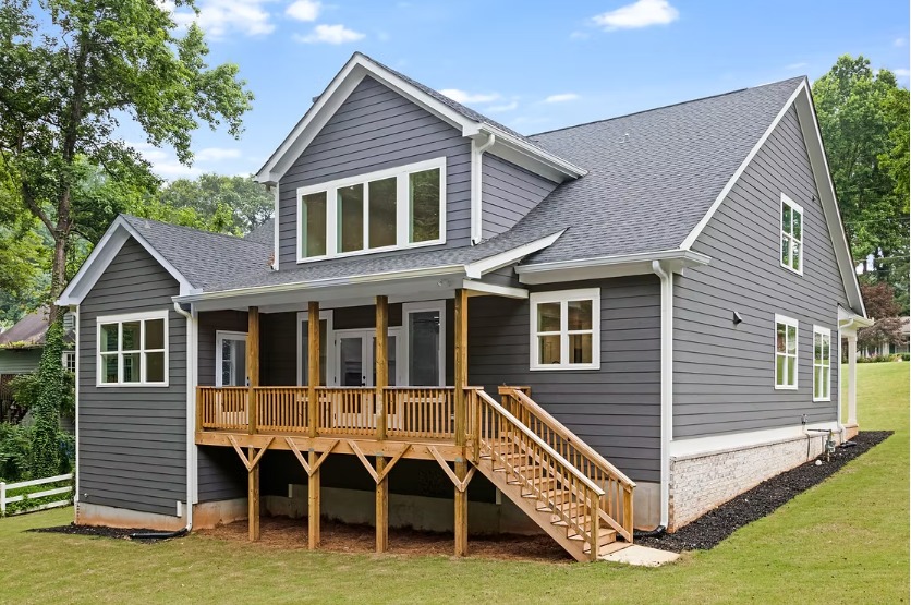 Rear elevation of the Stone Mountain new construction home with an elevated pressure-treated deck and stair run